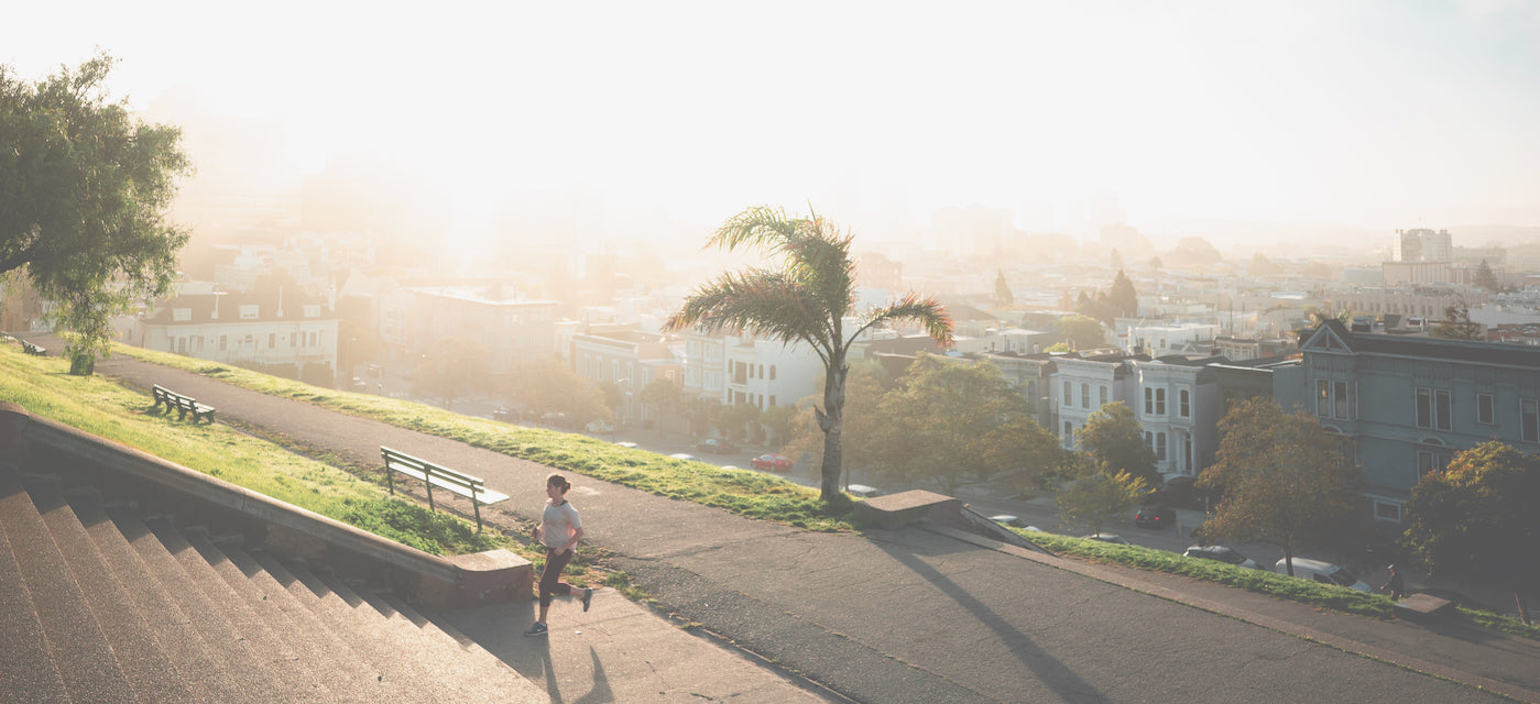 A woman running stairs in an urban park